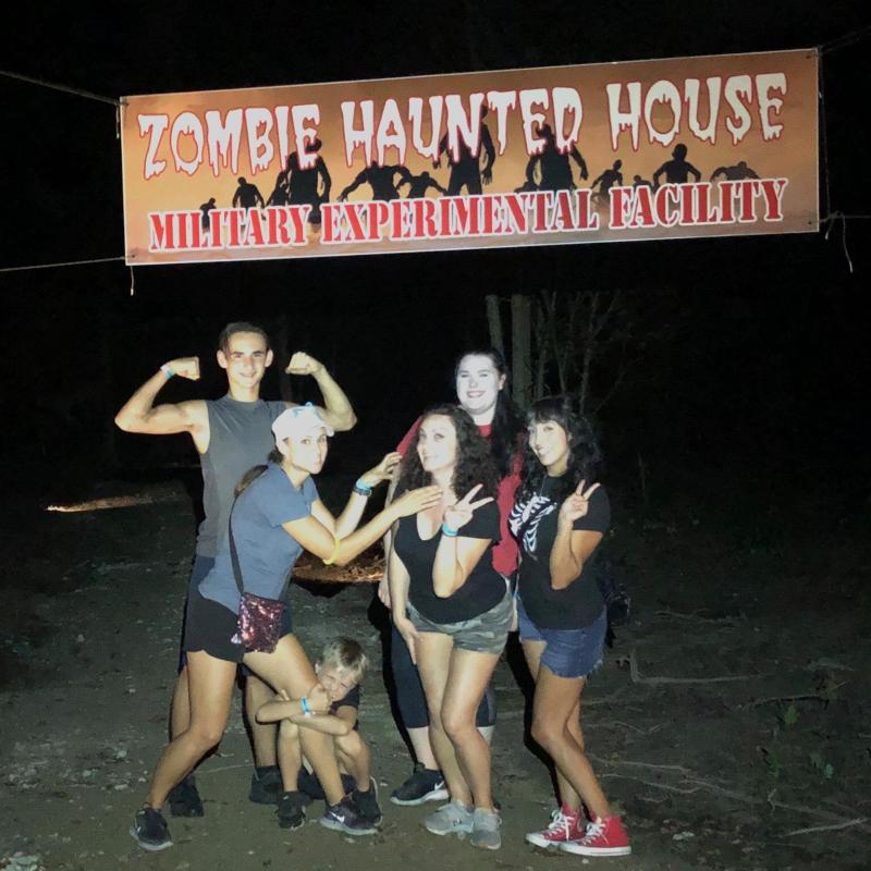 a group of people standing in front of a sign